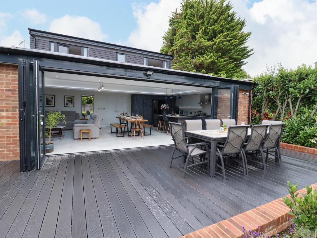 an open patio with a table and chairs on a deck at Kite View Cottage in High Wycombe