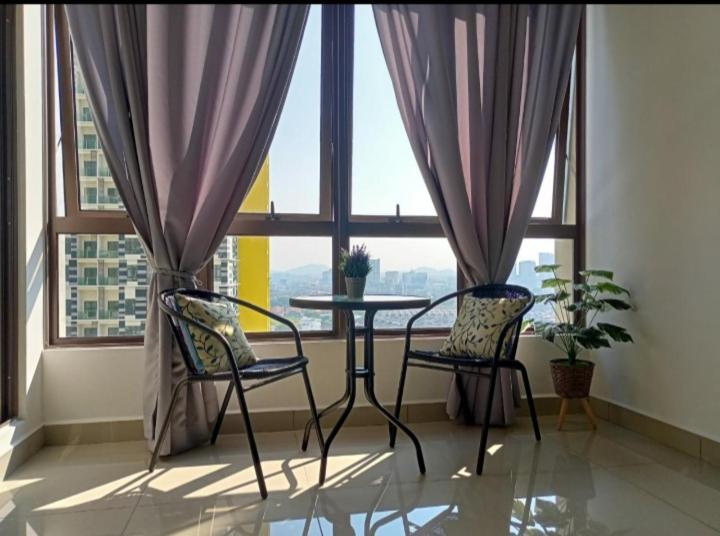 マラッカにあるBali Residence Melaka by Naufalの窓際の椅子2脚とテーブルが備わる客室です。