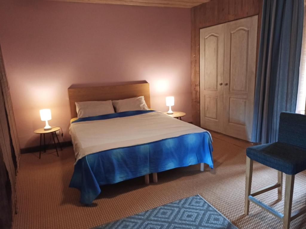 - une chambre avec un lit, deux lampes et une chaise dans l'établissement APPARTEMENT 