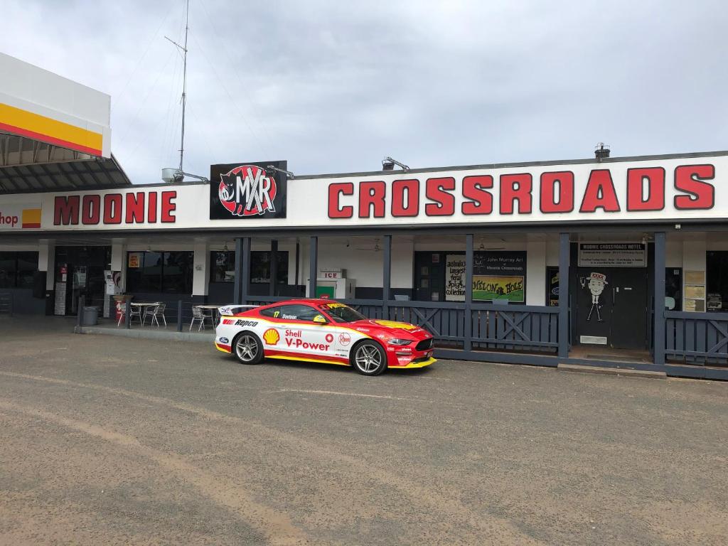 a car is parked in front of a store at The Moonie Crossroads Hotel in Moonie
