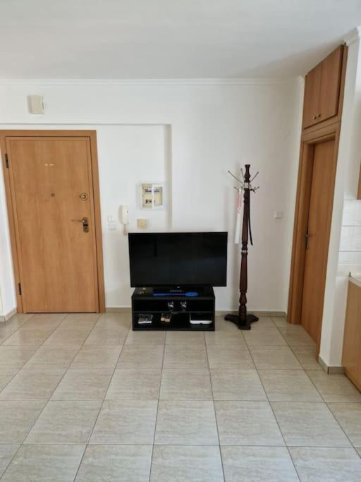 a living room with a flat screen tv and a tripod at Πλήρως εξοπλισμένο διαμέρισμα. in Nea Moudania
