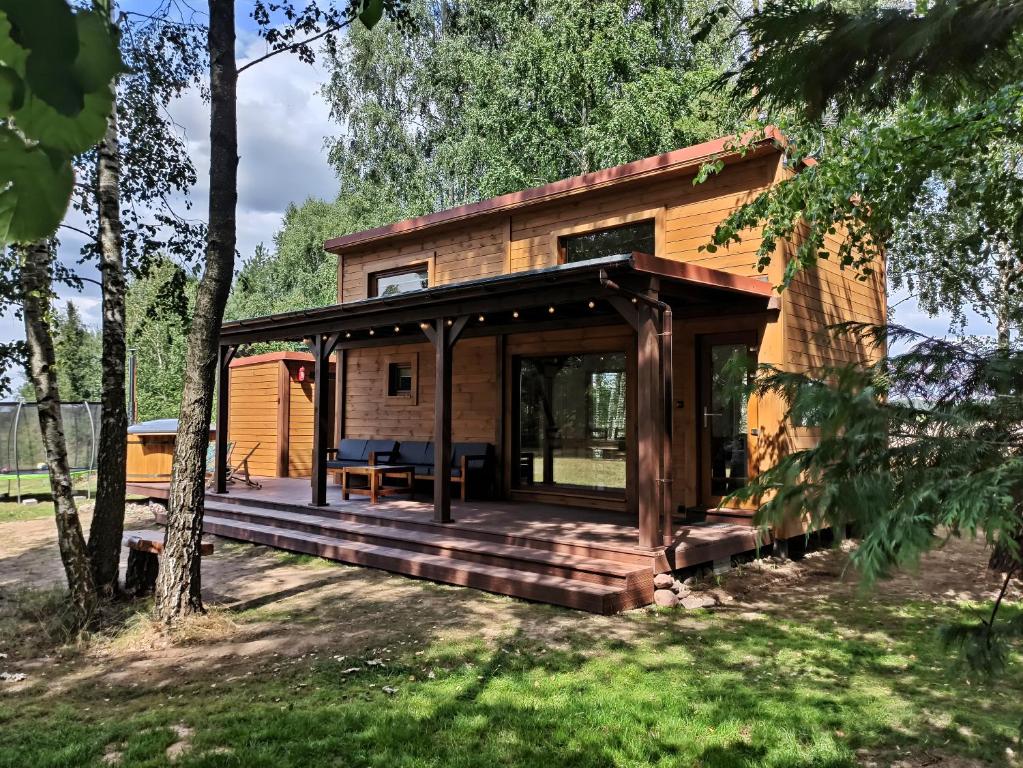 eine Hütte im Wald mit einer großen Terrasse in der Unterkunft Dębowe Siedlisko Chechłówka 