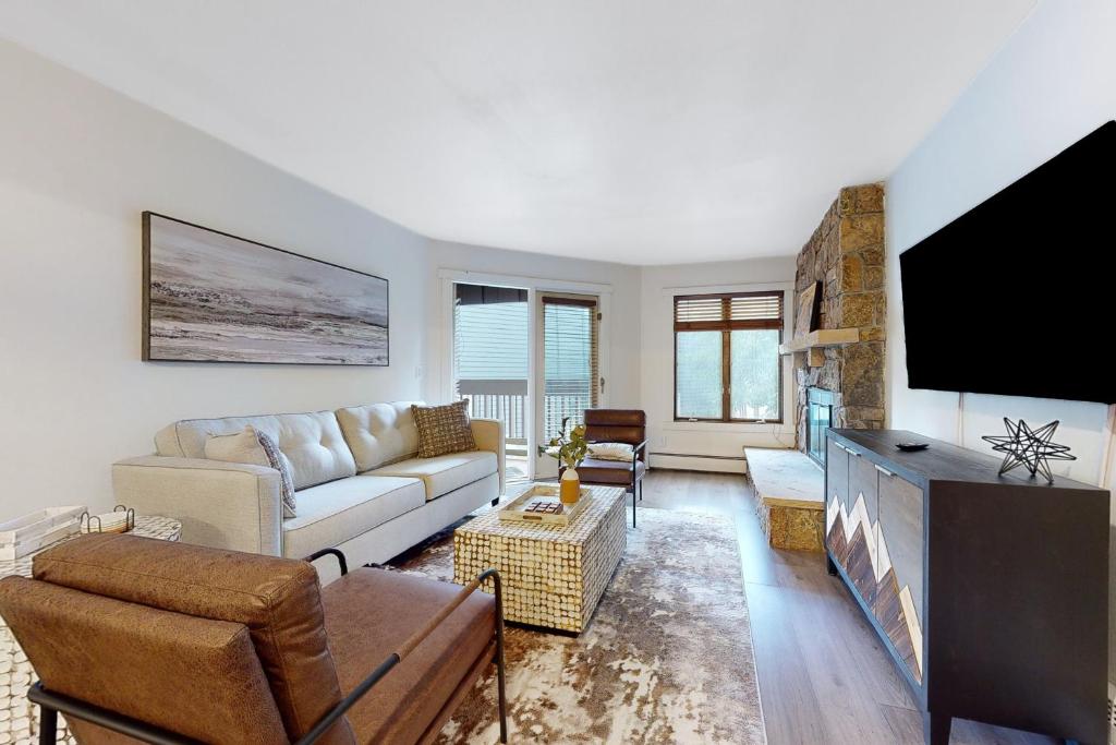 a living room with a couch and a flat screen tv at The Copperado at Copper Valley in Copper Mountain