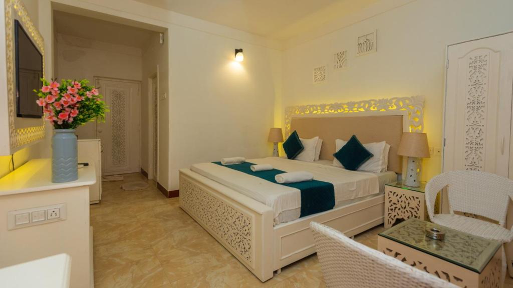 a bedroom with a large white bed in a room at Lillywoods NV Beach Resort in Calangute