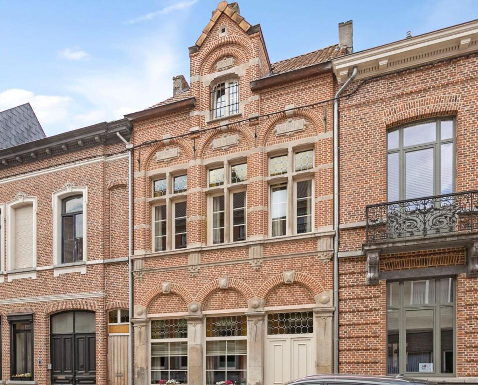 un ancien bâtiment en brique avec une tour d'horloge en haut dans l'établissement Manoir Hamme, à Hamme