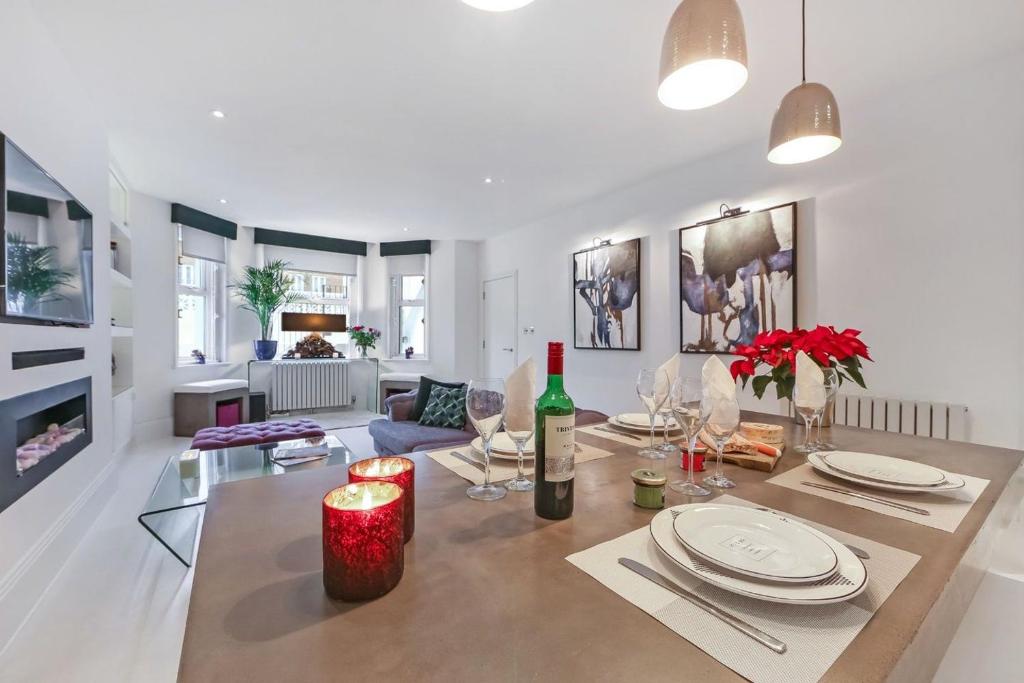 uma sala de estar com uma mesa e uma garrafa de vinho em Stylish Apartment with BBQ Kensington em Londres