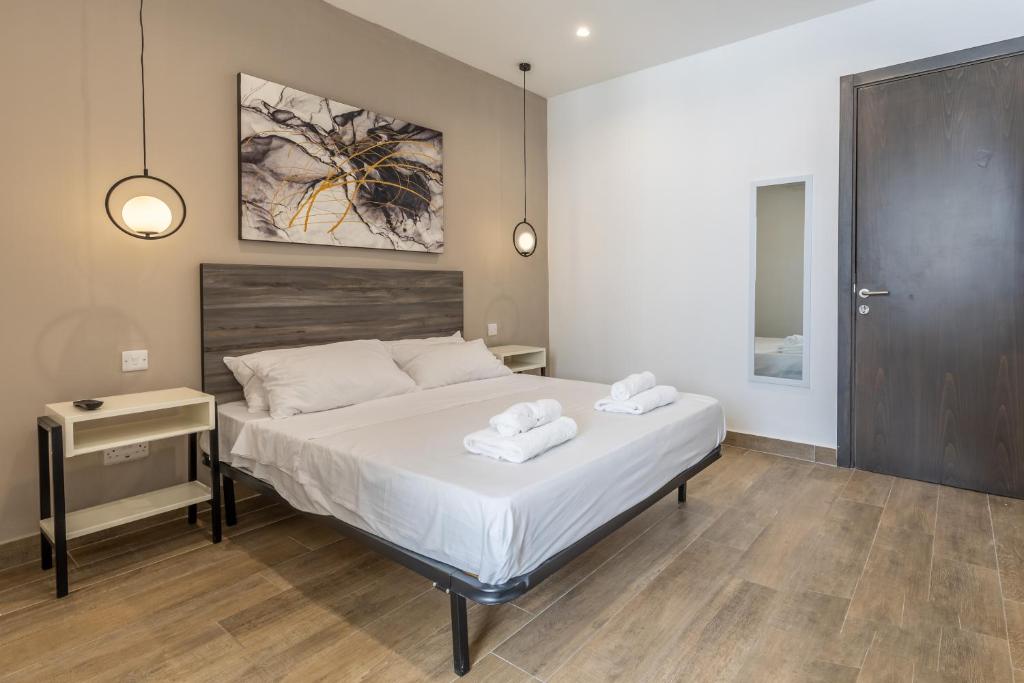 1 dormitorio con 1 cama con 2 toallas en Studio 42 with kitchenette at the new Olo living en Paceville