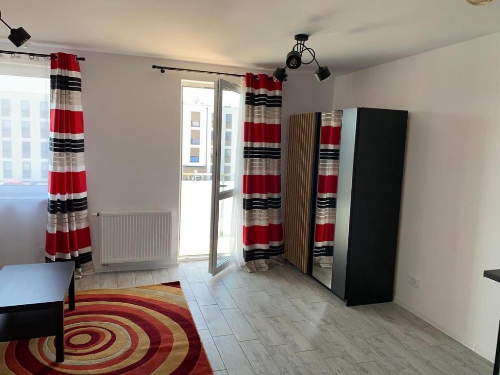 a room with red and white curtains and a rug at Apartamenty Wieliszew in Wieliszew
