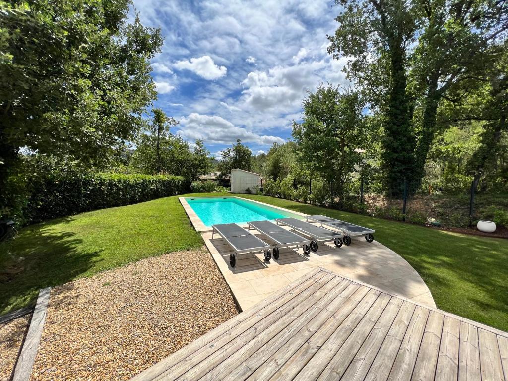 - une piscine avec un banc à côté d'une terrasse en bois dans l'établissement Luxury Villa with Pool en Provence, à Le Puy-Sainte-Réparade