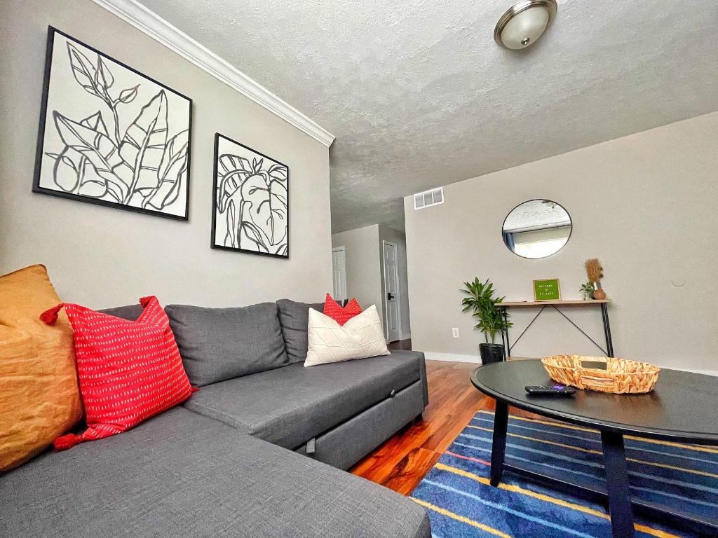 a living room with a gray couch and a table at Quiet & Quaint apartment, 5 mins to airport and 15 mins to downtown in Atlanta