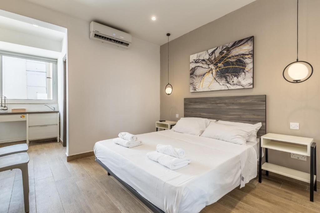 a bedroom with a bed with two towels on it at Studio 32 - Apartment & kitchenette at the new Olo living in Paceville