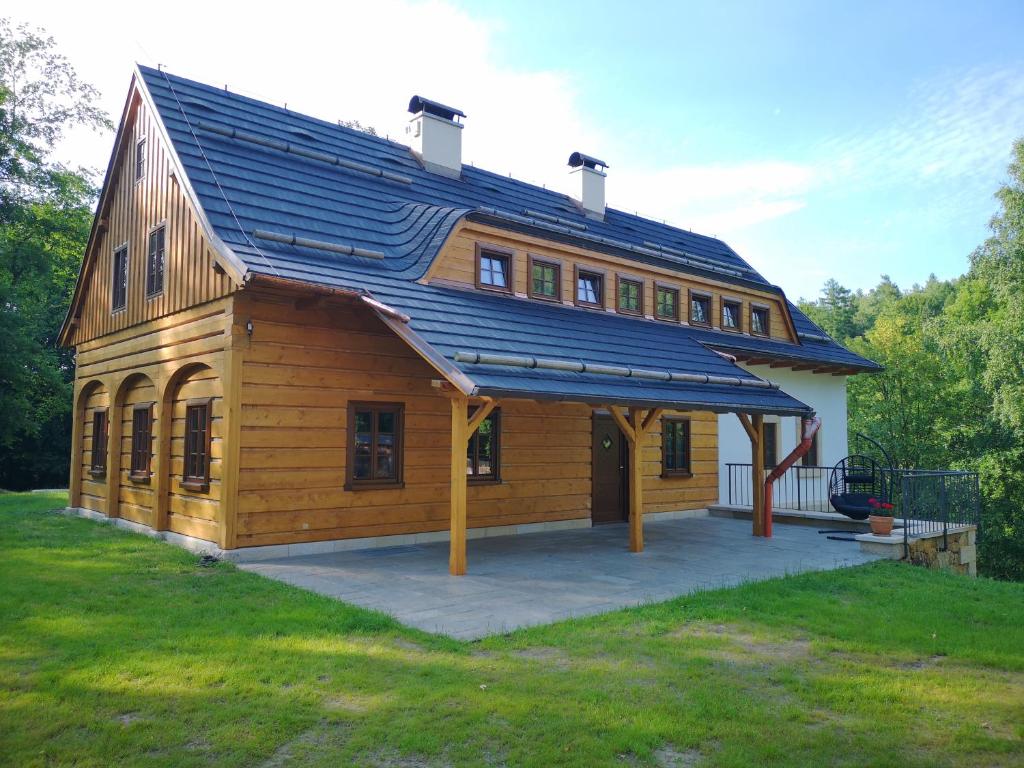 ein großes Holzhaus mit einem Gamer-Dach in der Unterkunft Na jelení stezce in Chřibská