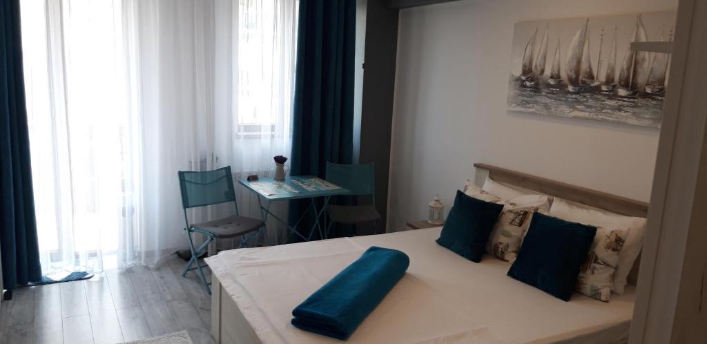 a bedroom with a bed with blue pillows on it at Studio Callatis Central - adults only in Mangalia