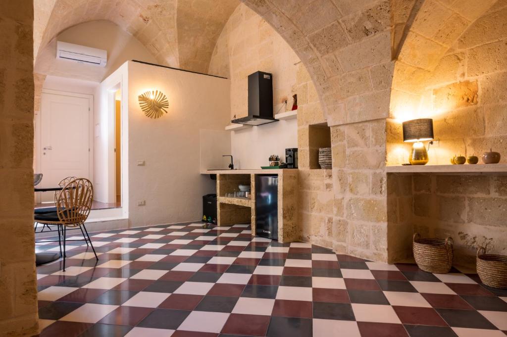 a living room with a checkered floor and a kitchen at le CASINE di MARUGGIO 19 in Maruggio