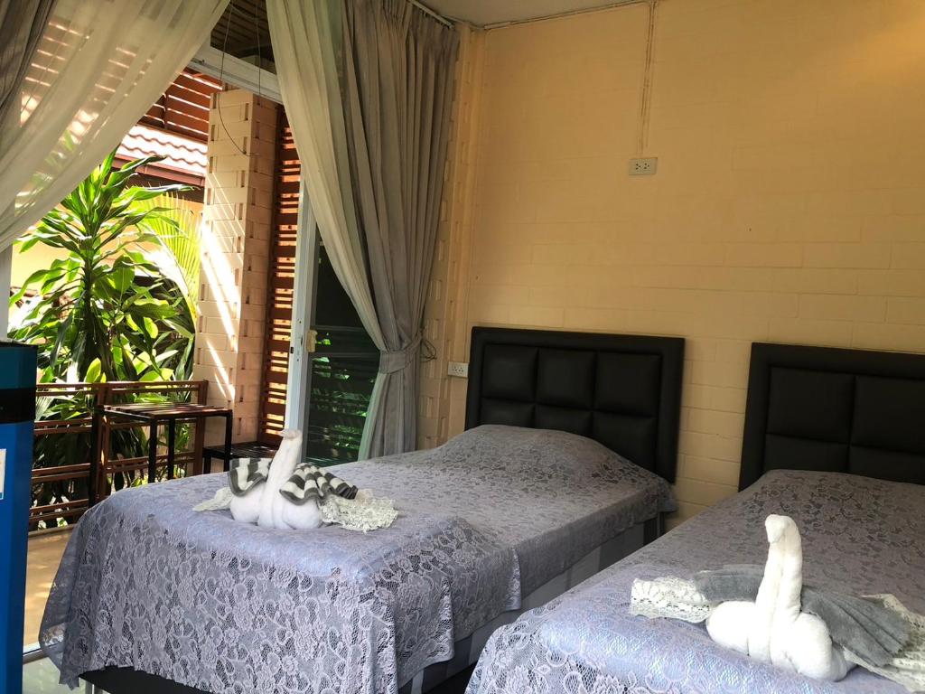 twee bedden in een kamer met twee zwanen erop bij Cool Cat House Resort 