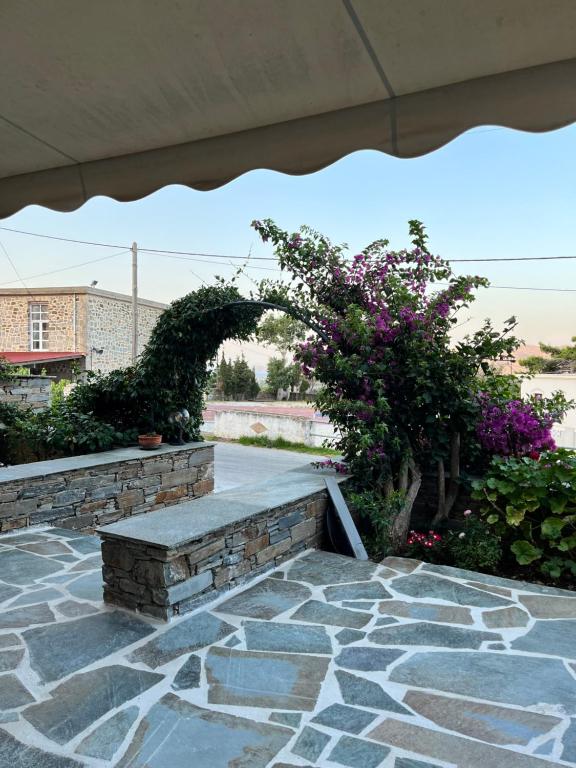 un banco de piedra en la parte superior de un patio en Giasemi apartments, en Caristo