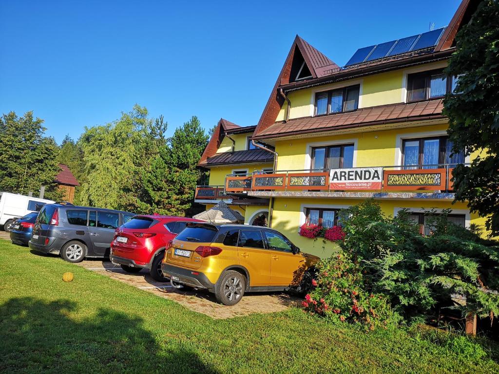 un gruppo di auto parcheggiate di fronte a un hotel di Noclegi Arenda a Niedzica