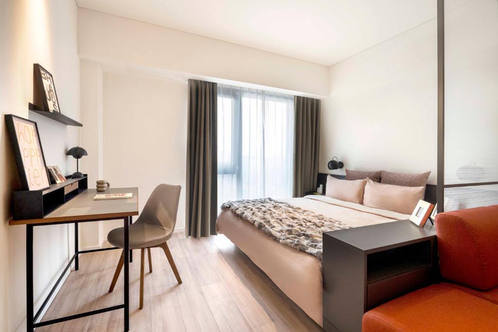 a hotel room with a bed and a desk at base-Beijing Wangfujing Serviced Apartment- in Hutong &Bike rental &Close to Forbidden City, Tian'anmen Square &Subway nearby &Free coffee &Washing machine,Kitchen &Restaurant discount &English speaking &High speed free WiFi in Beijing