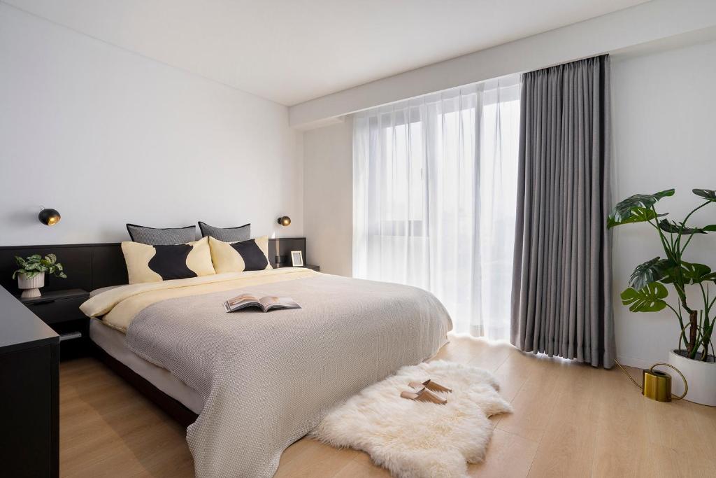 a bedroom with a large bed and a large window at base-Beijing Wangfujing Serviced Apartment- in Hutong &Bike rental &Close to Forbidden City, Tian'anmen Square &Subway nearby &Free coffee &Washing machine,Kitchen &Restaurant discount &English speaking &High speed free WiFi in Beijing