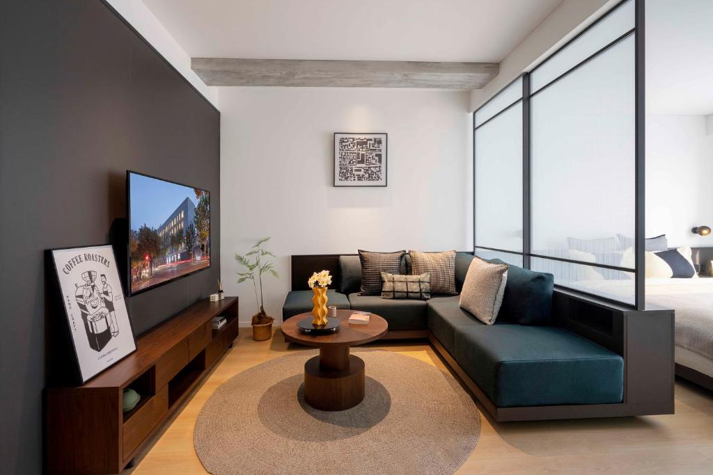 a living room with a couch and a tv at base-Beijing Wangfujing Serviced Apartment- in Hutong &Bike rental &Close to Forbidden City, Tian'anmen Square &Subway nearby &Free coffee &Washing machine,Kitchen &Restaurant discount &English speaking &High speed free WiFi in Beijing