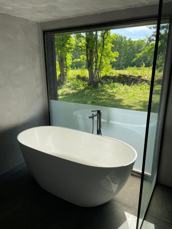 a white bath tub in a bathroom with a window at Kaasiku-Liiva Talu in Jõgela