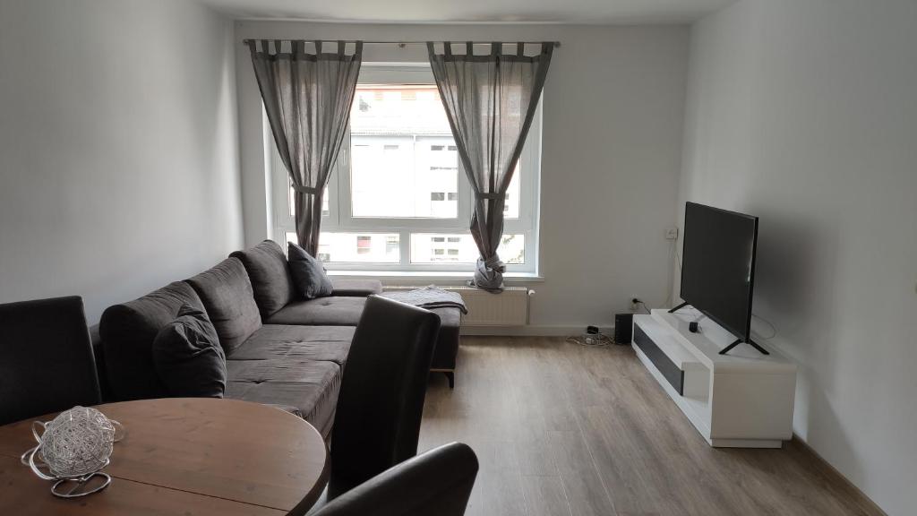 a living room with a couch and a tv and a table at Wohnung Meeresbrise 48 qm mit Balkon in Rostock