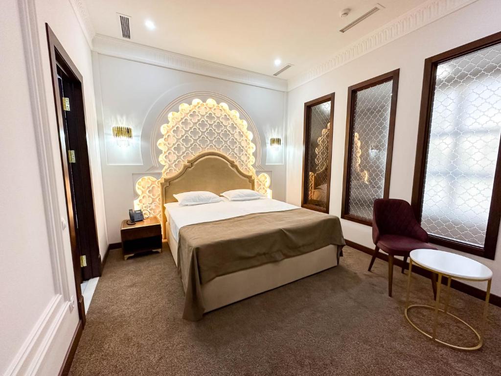 a bedroom with a large bed with a gold headboard at Reikartz Sote Tashkent in Tashkent