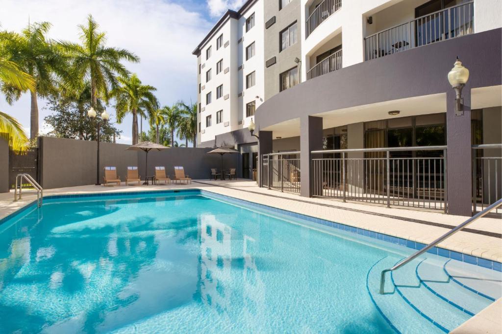 una piscina di fronte a un edificio di Courtyard by Marriott Miami at Dolphin Mall a Miami