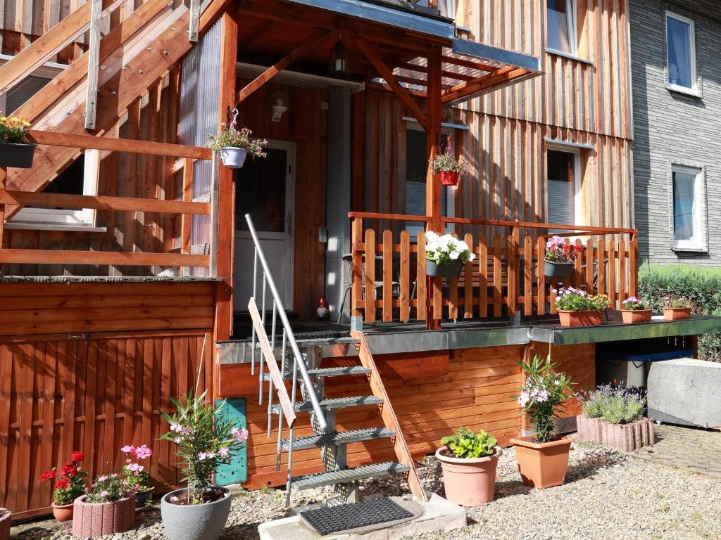 un porche de una casa con macetas. en Haus am Kroatenbach en Lautenthal