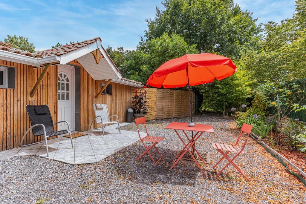 a patio with a table and chairs and an umbrella at Studio Bassin d'arcachon in La Teste-de-Buch