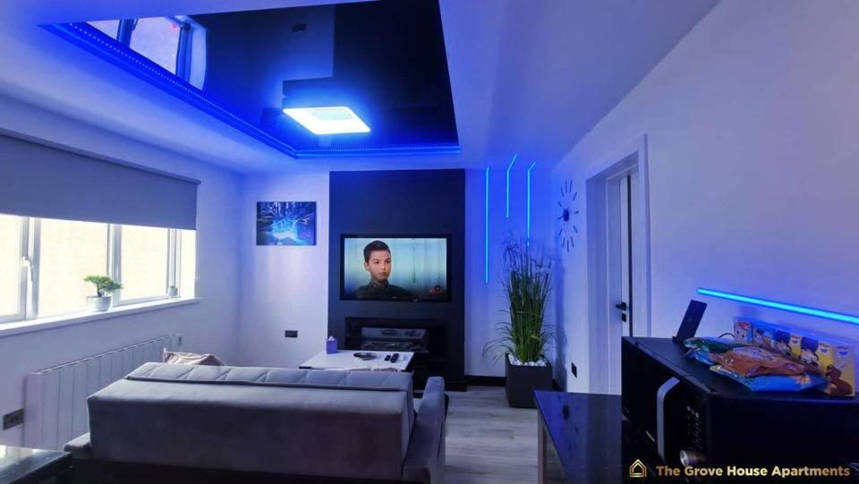 #6 TGHA Luxury Two Bedroom Apartment in Athlone في آثلون: غرفة زرقاء مع أريكة وحوض أسماك
