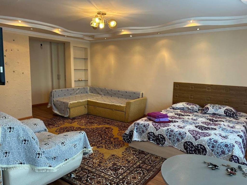 カラガンダにあるУютная квартира Н.Абдирова 32のベッドルーム1室(ベッド2台、テーブル付)