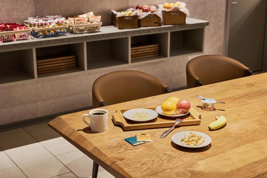 a wooden table with plates of fruit on it at Orange Hotel - Ximen, Taipei in Taipei