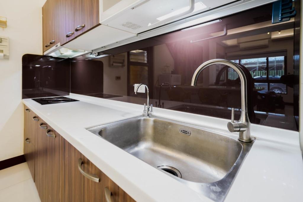 a kitchen with a stainless steel sink in an rv at 墾丁包棟民宿-曜凱樂 in Jen-shou