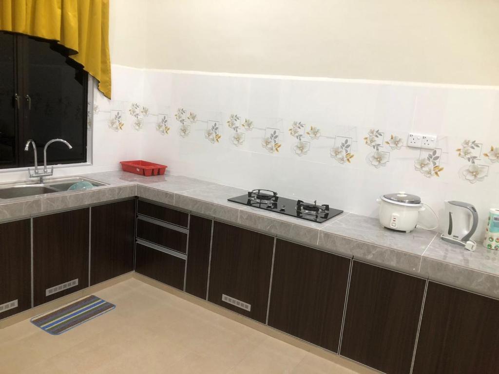 a kitchen with a sink and a counter top at HOMESTAY CIK PHIA in Kuala Terengganu