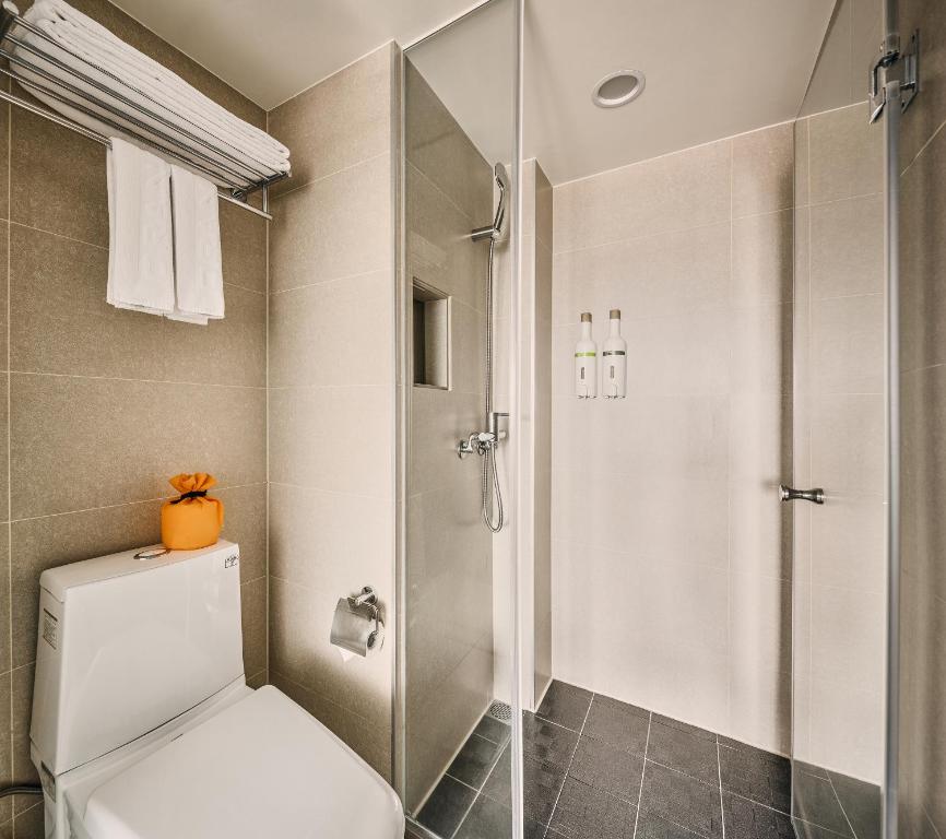 a bathroom with a toilet and a glass shower at Orange Hotel - Ximen, Taipei in Taipei