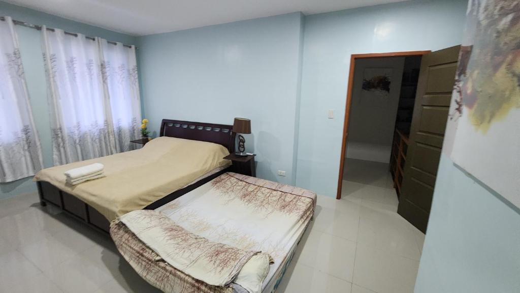 ein Schlafzimmer mit einem Bett und einem Stuhl darin in der Unterkunft Cozy 3Bedroom Home for A Big Family and Friends in Cagayan de Oro