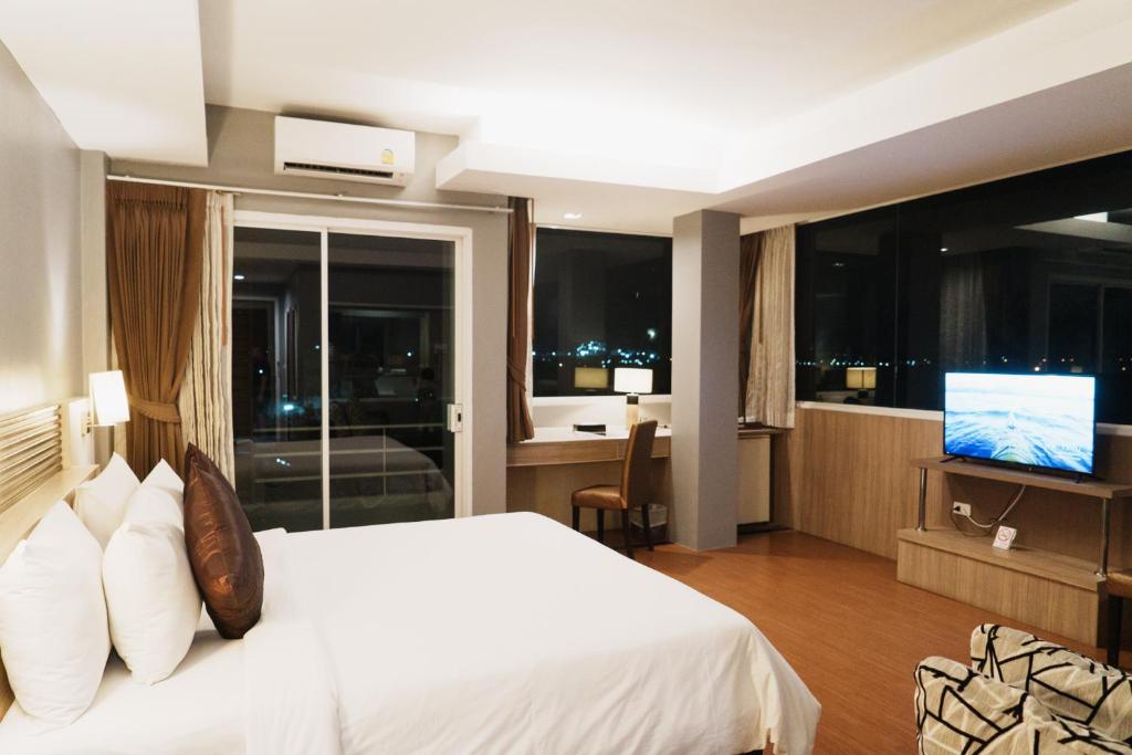 um quarto de hotel com uma cama e uma televisão em Green Hotel and Resort em Khon Kaen