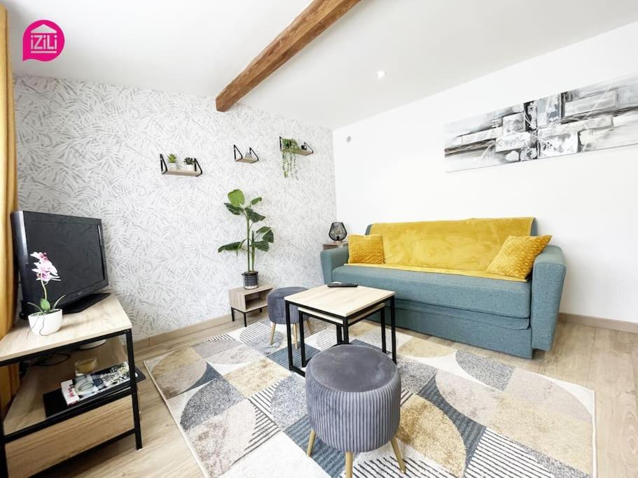 uma sala de estar com um sofá azul e uma televisão em Le Nouaillé by iZiLi - Calme et confort - Parking em Poitiers