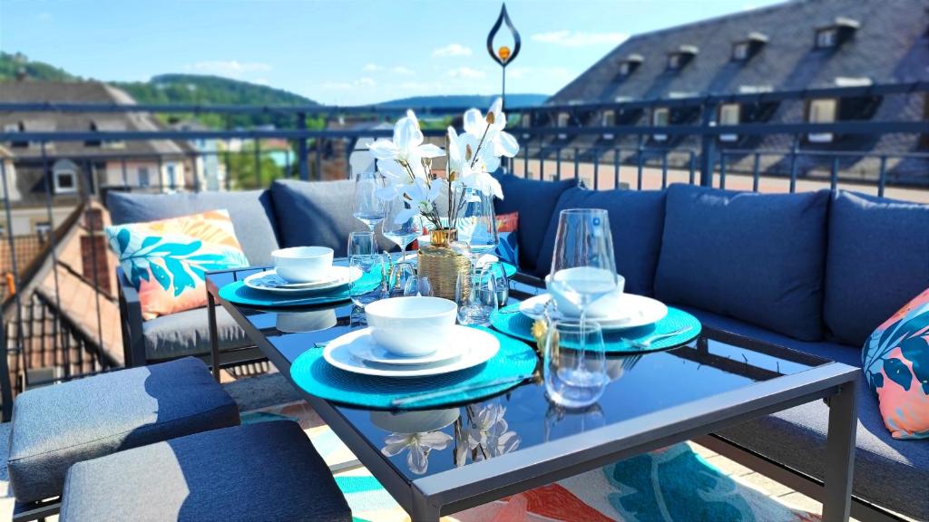 einen blauen Tisch mit Tellern und Gläsern auf dem Balkon in der Unterkunft ELApart by Homely Stay - Moderne Apartments mit Self-Check-in in Bad Kissingen