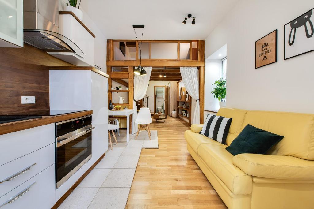 a living room with a yellow couch and a kitchen at La Guardia apartment with free private parking in Rijeka