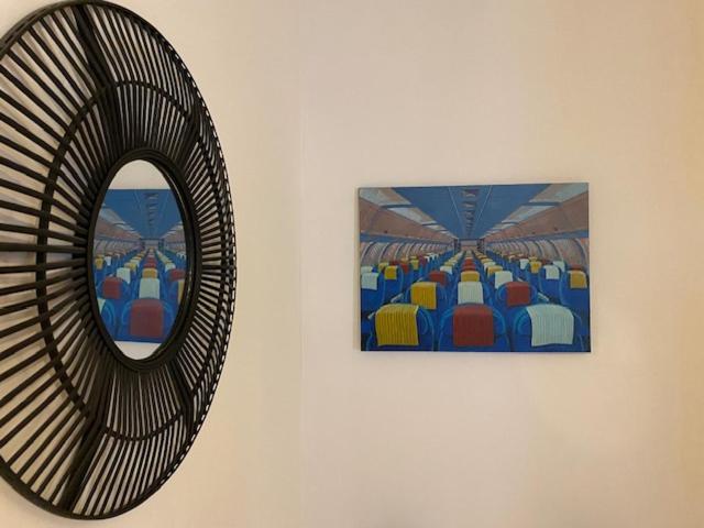um espelho e um quadro na parede em Le studio de l'artiste. em Arles