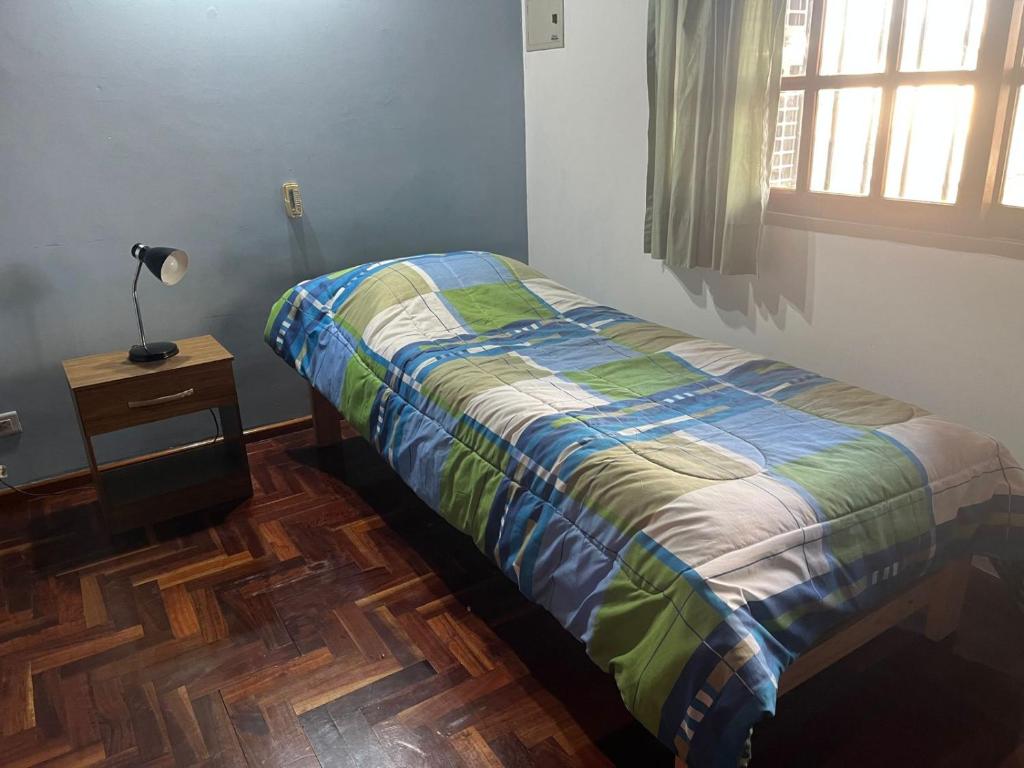 a bedroom with a bed and a lamp and a window at Experiencia Olivos in Florida