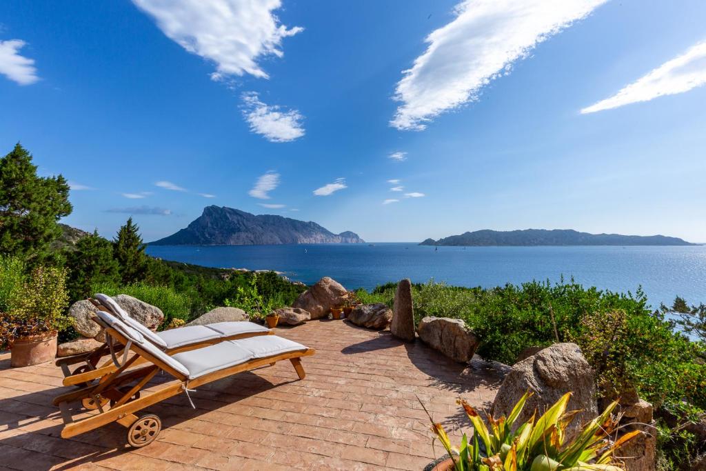 a chaise lounge on a brick patio next to the water at Villa Rubia - Belocations in Monte Petrosu