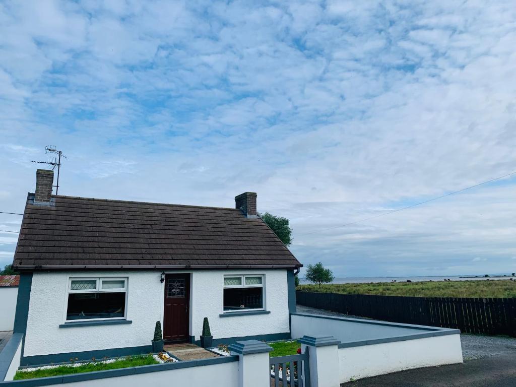 a white house with a brown roof at Farsnagh Cottage 