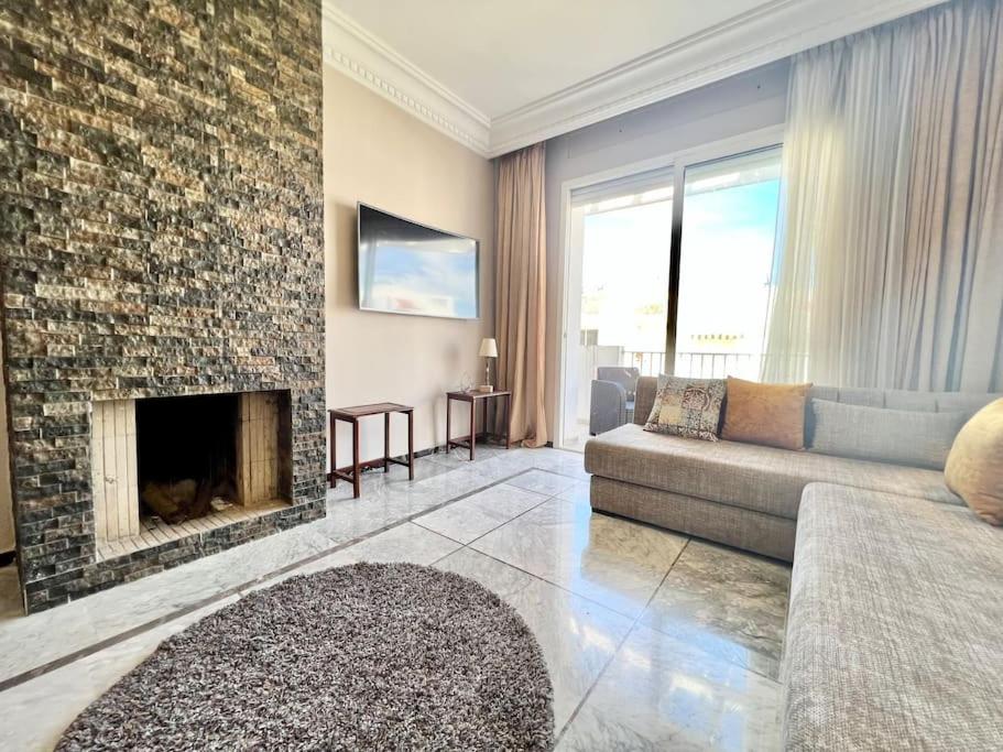 a living room with a couch and a fireplace at Appartement face à la mer et à 10min du centre-ville in Casablanca