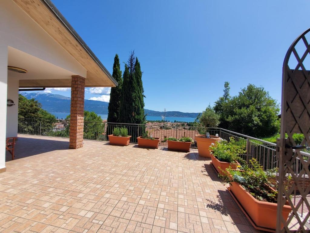 a patio with potted plants and a fence at Garda Sunshine in Toscolano Maderno