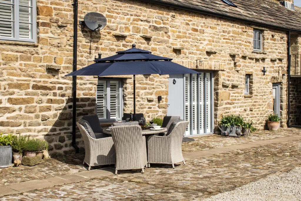 a table with chairs and an umbrella in front of a building at Beckside in West Burton