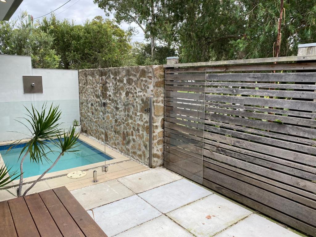 une clôture en bois avec une piscine dans l'arrière-cour dans l'établissement Worrowing Jervis Bay, à Huskisson