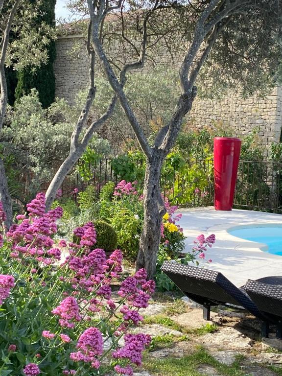 a garden with a bench and flowers and a tree at Mas de la Beaume in Gordes